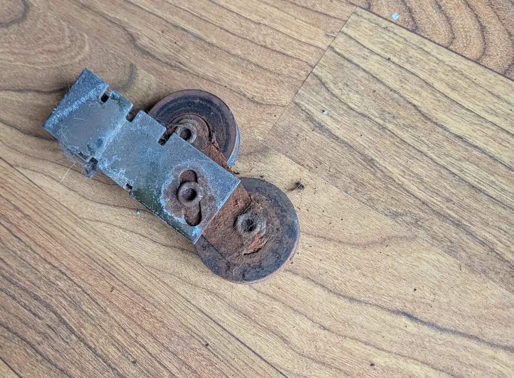 Old rusted sliding door roller removed from a door
